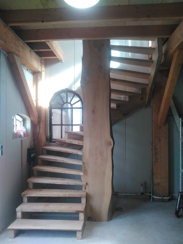 Massief houten trap met boomstamdetail in aanbouw